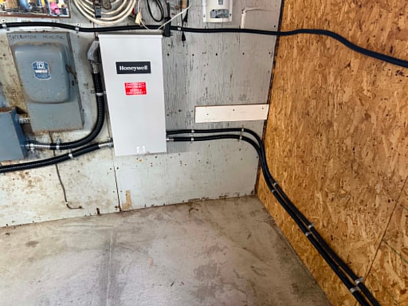 Commutateur de transfert automatique installé au mur à côté de l'interrupteur principal, raccordé en conduits flexibles